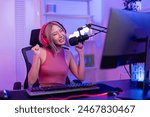 Asian young audio DJ woman dance with music and broadcasting in studio. Attractive beautiful female blogger influencer wearing headphones and recording mixing dance rhythm show for radio in neon room.