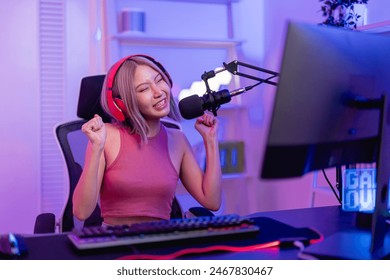 Asian young audio DJ woman dance with music and broadcasting in studio. Attractive beautiful female blogger influencer wearing headphones and recording mixing dance rhythm show for radio in neon room. - Powered by Shutterstock