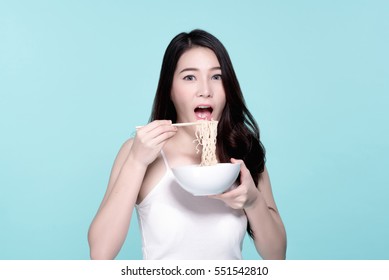 Asian Young Beautiful Woman Eating Hot And Spicy Instant Noodle,  Beauty Face Natural Makeup, Isolated Over Blue Background.