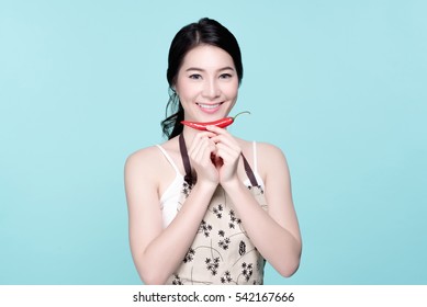 Asian Young Beautiful Woman Holding Red And Green Chili Pepper, Hot And Spicy Food, Natural Makeup, Beauty Face, Isolated Over Blue Background.