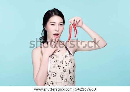 Asian young beautiful woman holding red and green chili pepper, hot and spicy food, natural makeup, beauty face, isolated over blue background.