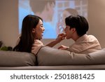 Asian young beautiful woman watching romantic movie on television at home. Attractive girl sitting on sofa feel happy and excited, watch romantic comedy series on TV show. Activity lifestyles concept.