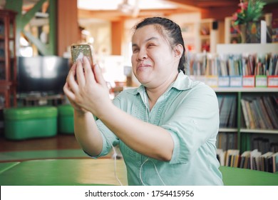 Asian Young Blind Person Woman Disabled People Taking Selfie Or Video Call Using Smart Phone In Creative Workplace