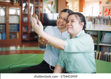 Asian Young Blind Person Woman Disabled People Taking Selfie Using Smart Phone With Her Senior Colleague Woman In Creative Workplace