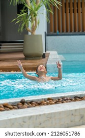 Asian Young Boy Having A Good Time In Swimming Pool, He Jumping And Playing A Water In Summer.