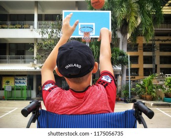 Asian Young Boy In Wheelchair Is Trying To Practice Basketball After Convalesce From Torn Ankle Ligament At Tha Cha Lom, Samutsakhon, Thailand, 09092018