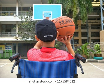 Asian Young Boy In Wheelchair Is Trying To Practice Basketball After Convalesce From Torn Ankle Ligament At Tha Cha Lom, Samutsakhon, Thailand, 09092018