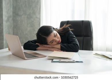 Asian Young Business Girl Sleeping On The Desk In Front A Laptop In The Office. Concept Exhausted From Work.