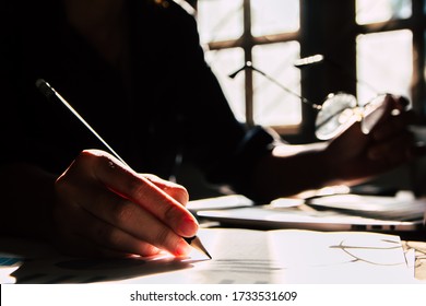 Asian Young Business Man Of Student Holding A Pen Writing Letter On Paper At Home. Silhouette Photo