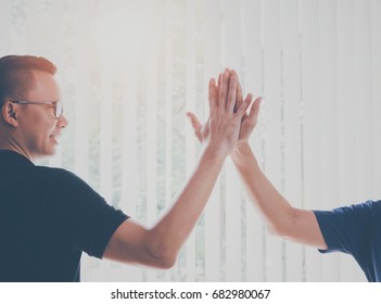 Asian Young Businessman Giving Hi Five,touching Hands During Business Meeting In Home Office Background With Vintage Tone.Concept Of Achievement And Success With Teamwork.