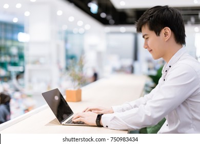 Asian Young Businessman Using Laptop At His Office Desk.