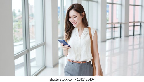 Asian Young Businesswoman Use Smart Phone While Commuting In City