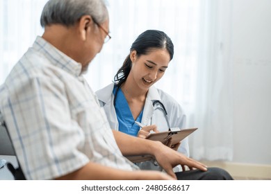 Asian young caregiver take care senior man on wheelchair in house. Attractive nurse doctor support elderly older mature male patient doing physical therapy at nursing home care. Medical insurance. - Powered by Shutterstock