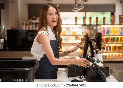 An Asian young Cashier woman working in supermarket - Powered by Shutterstock - Get 15% off with code: PIKWIZARD15