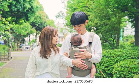 Asian young couple  and a baby walking in green park. Child rearing. Newborn. - Powered by Shutterstock