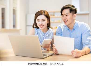 Asian Young Couple Calculate Expenses Finance By Laptop And Discuss Plan Together At Home