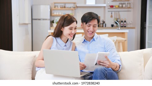 Asian Young Couple Calculate Expenses Finance With Laptop And Discuss Plan Together At Home