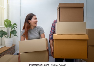 Asian Young Couple Carrying Big Cardboard Box For Moving In New Home, Moving And House Hunting Concept