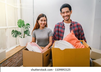 Asian Young Couple Carrying Big Cardboard Box For Moving In New House, Moving And House Hunting Concept