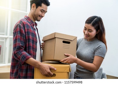 Asian Young Couple Carrying Big Cardboard Box For Moving In New House, Moving And House Hunting Concept