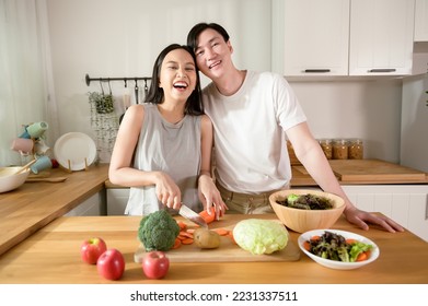 An Asian young couple enjoy cooking with healthy vegetables and fruits ingredients in kitchen at home , healthy wellness lifestyle concept. - Powered by Shutterstock