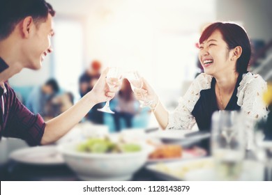 Asian Young Couple Enjoying A Romantic Dinner  Evening Drinks While Sitting At The Dinning Table On The Kitchen Together At Home ,soft Focus