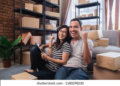 Asian Young Couple Entrepreneur With Packages At Home. Market Place Online Seller Concept