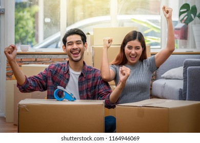 Asian Young Couple Are Glad After Successfull Packing The Big Cardboard Box For Moving In New Place, Moving And House Hunting Concept,