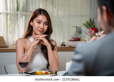 Asian Young Couple Having Dinner To Celebrate Valentine's Day Together. Attractive Romantic New Marriage Man And Woman Having Night Party Eat Foods On Table For Wedding Anniversary In Kitchen At Home.