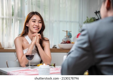 Asian Young Couple Having Dinner To Celebrate Valentine's Day Together. Attractive Romantic New Marriage Man And Woman Having Night Party Eat Foods On Table For Wedding Anniversary In Kitchen At Home.