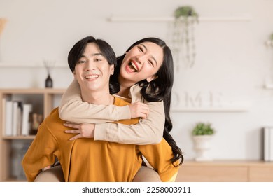 Asian young couple hugging with positive emotion and loving together at warmth place. Attractive man and woman embracing spending time together at home. Couple love and Valentine's Day concept - Powered by Shutterstock