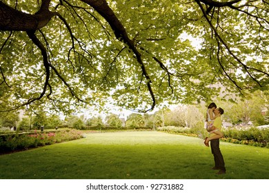 Asian Young Couple Kissing Under Tree Near St. Patrick Cathedral, Melbourne - Australia