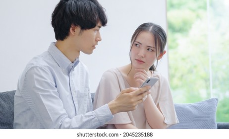 Asian young couple looking at a smartphone