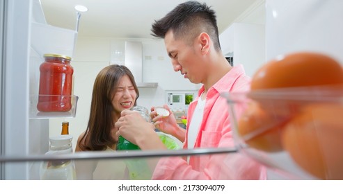 Asian Young Couple Open Refrigerator In Kitchen And There Has Bad Smell From Food Then They Pour It Into Trash