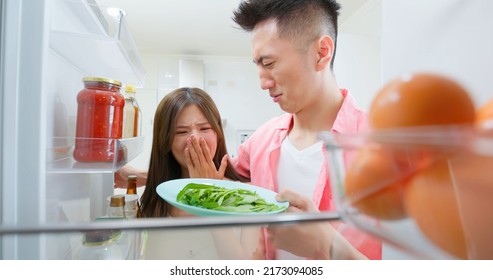 Asian Young Couple Open Refrigerator In Kitchen And There Has Bad Smell From Food Or Dishes