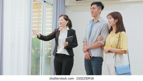 Asian Young Couple With Real Estate Agent Visiting House For Sale Or Rent - Realtor Introduces Building In House