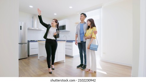 Asian Young Couple With Real Estate Agent Visiting House For Sale Or Rent - Realtor Introduces Building At Kitchen