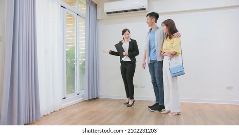 Asian Young Couple With Real Estate Agent Visiting House For Sale Or Rent