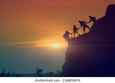 Asian Young Couple Silhouette Climbing The Mountain Hiking And Teamwork Concept, Sunset Background