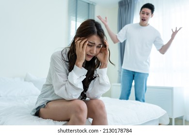 Asian young couple sitting on bed with painful after fight argument. New marriage man and woman crying and feel heartbroken for their quarrel conflict in bedroom. Family problem-separation concept. - Powered by Shutterstock