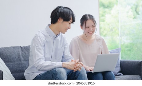 Asian Young Couple Using A Computer