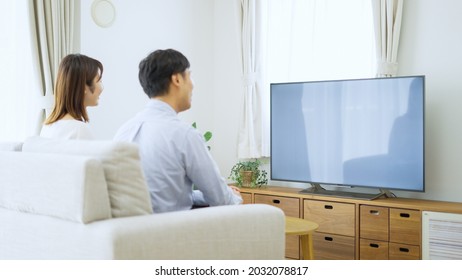 Asian Young Couple Watching Tv