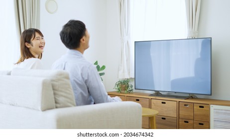 Asian Young Couple Watching Tv
