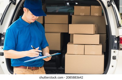 Asian young delivery man courier in uniform hold documents clipboard checking list parcel post boxes near a car for service shipment to customer, Online shopping service concepts - Powered by Shutterstock