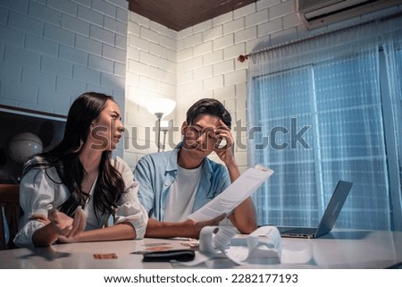 Asian young depressed couple having argument while checking money debt. Attractive new marriage man and woman looking frustrated to paperwork and bill, feel worried about financial problem in house. Stock photo © 