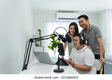 Asian Young DJ Man Speaking On Microphone At Studio With Loving Parent. Male Teenager Patient Person Feeling Happy And Relax While Recording News Podcast Show For Radio Broadcasting At Home Studio.