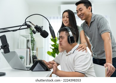 Asian Young DJ Man Speaking On Microphone At Studio With Loving Parent. Male Teenager Patient Person Feeling Happy And Relax While Recording News Podcast Show For Radio Broadcasting At Home Studio.