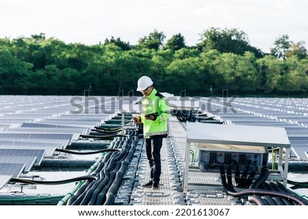 asian young engineer with Digital Tablet  in his hand who plans to expand the plant with solar panels. 