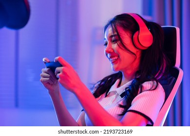 Asian Young E-sport Woman Gamer Play Online Mobile Game On Smartphone. Attractive Beautiful Girl Gaming Player Feel Happy Enjoy Technology Broadcast Live Streaming While Plays Cyber Tournament At Home