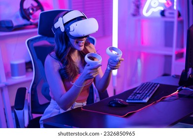 Asian young Esport woman gamer use technology VR glasses and play game. Attractive beautiful female gaming player wear virtual reality headset, feel excited and enjoy broadcast live stream online game - Powered by Shutterstock